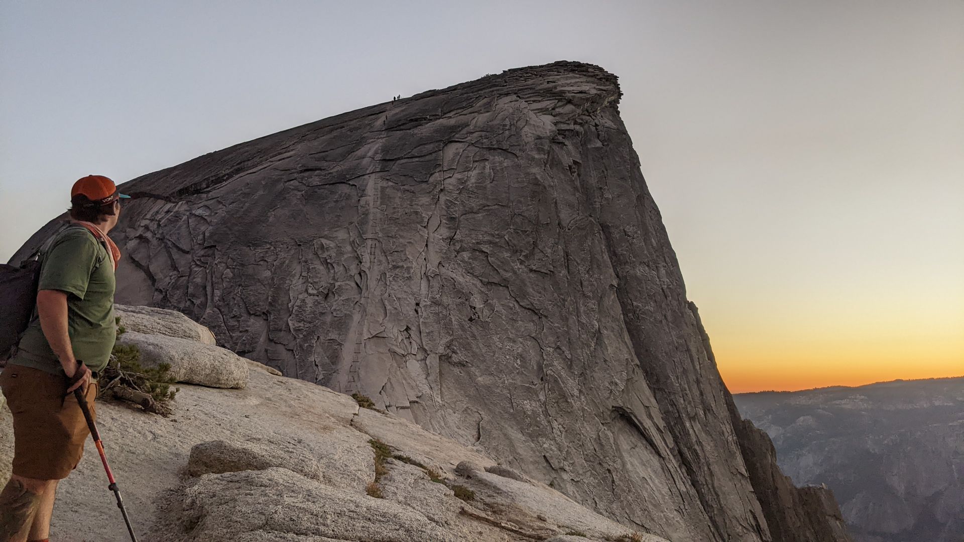 A man is standing on top of a rocky mountain.