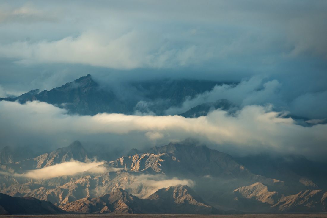 Clouds hug a rugged mountain range