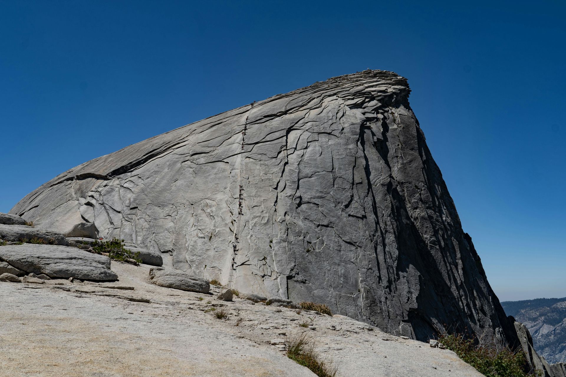 Granite rock formation under a clear blue sky, viewed from below