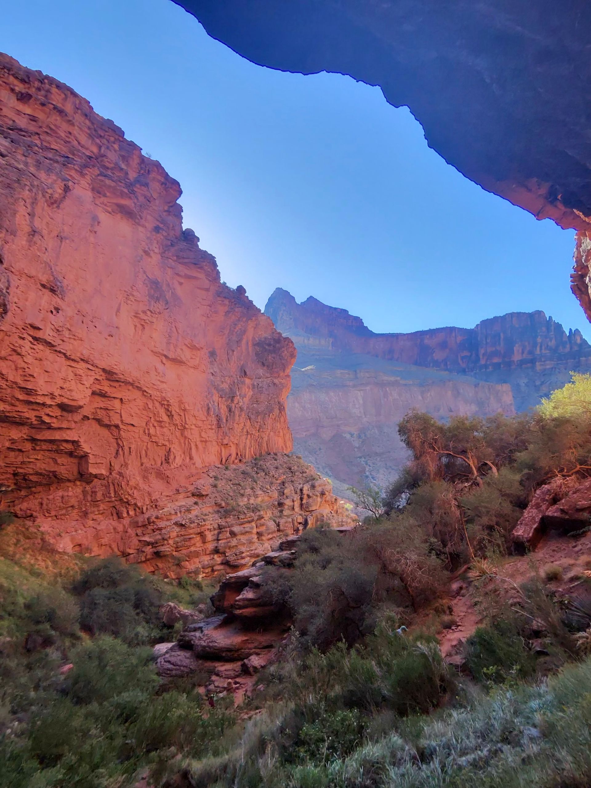 A canyon with red rocks and a blue sky in the background