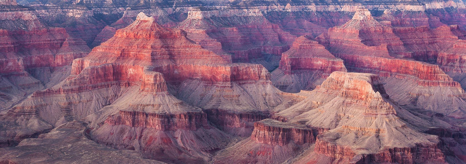 An aerial view of the grand canyon with mountains in the background