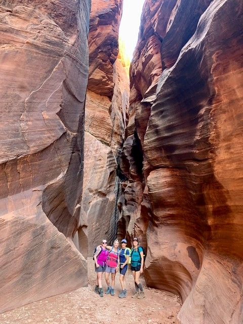 A group of people are standing in a canyon.