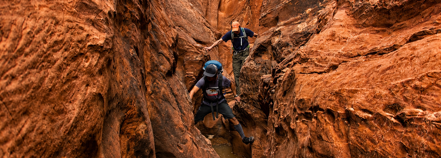 A group of people are hiking in the desert with backpacks.