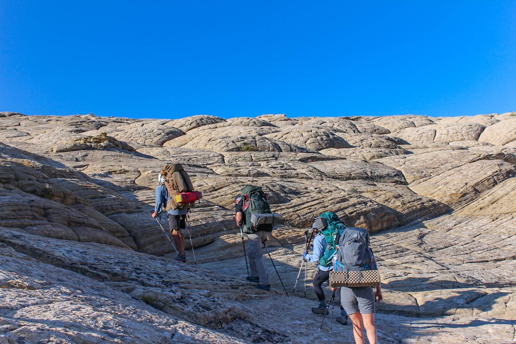 A Group of People Are Standing Under a Large Rock Formation