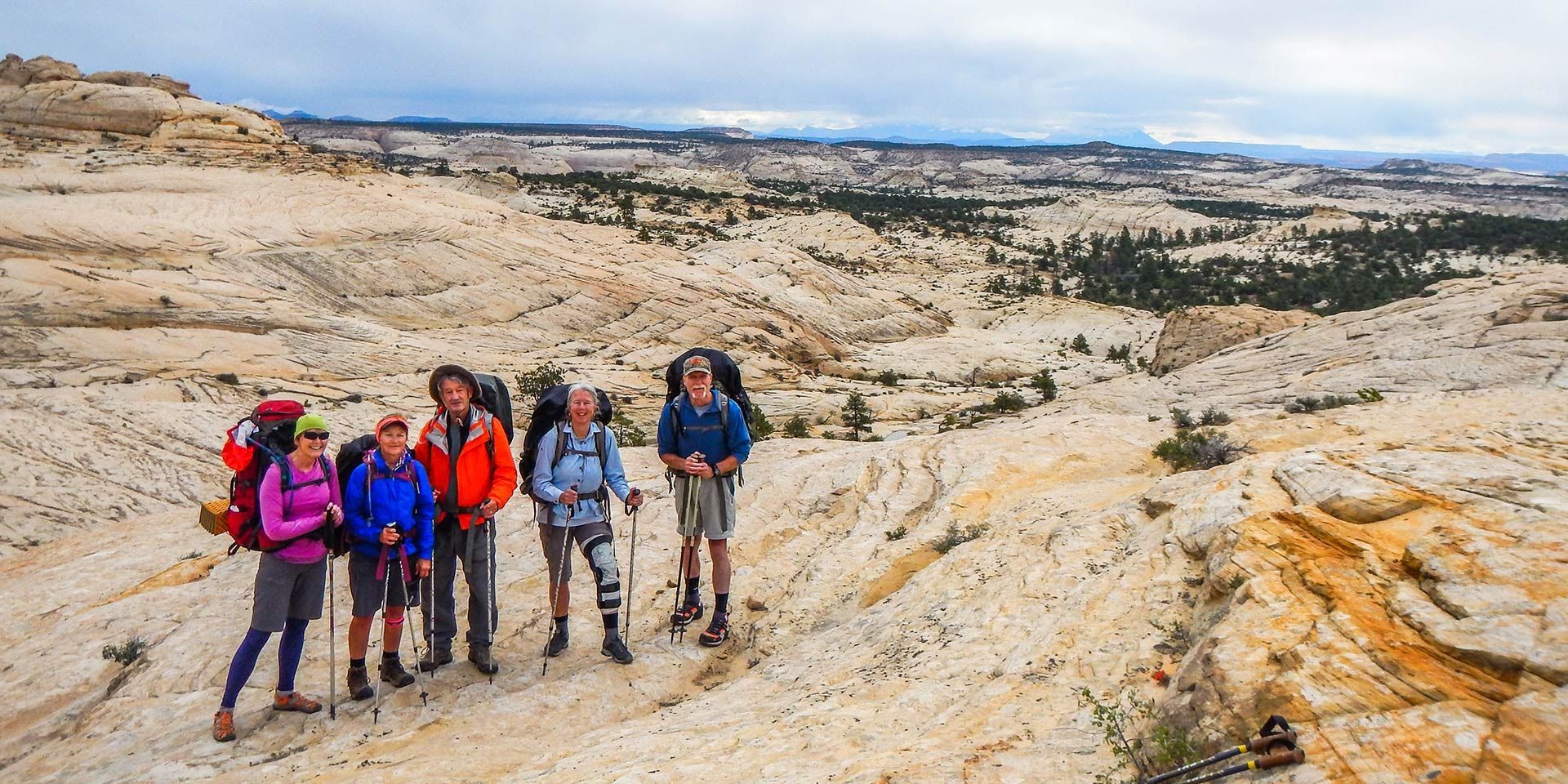 A group of people standing next to each other on top of a mountain.