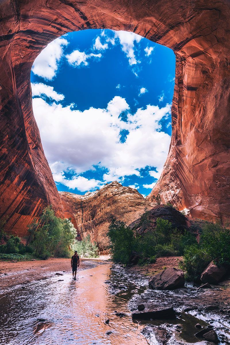 A man is walking through a cave in the desert.