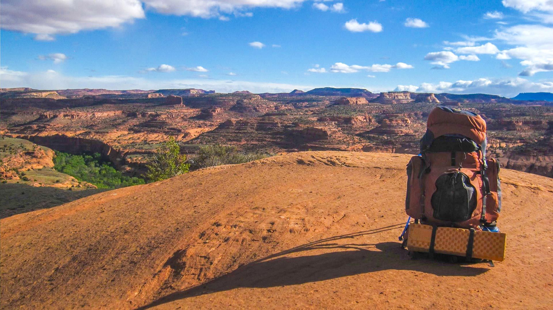 A backpack is sitting on top of a dirt hill.