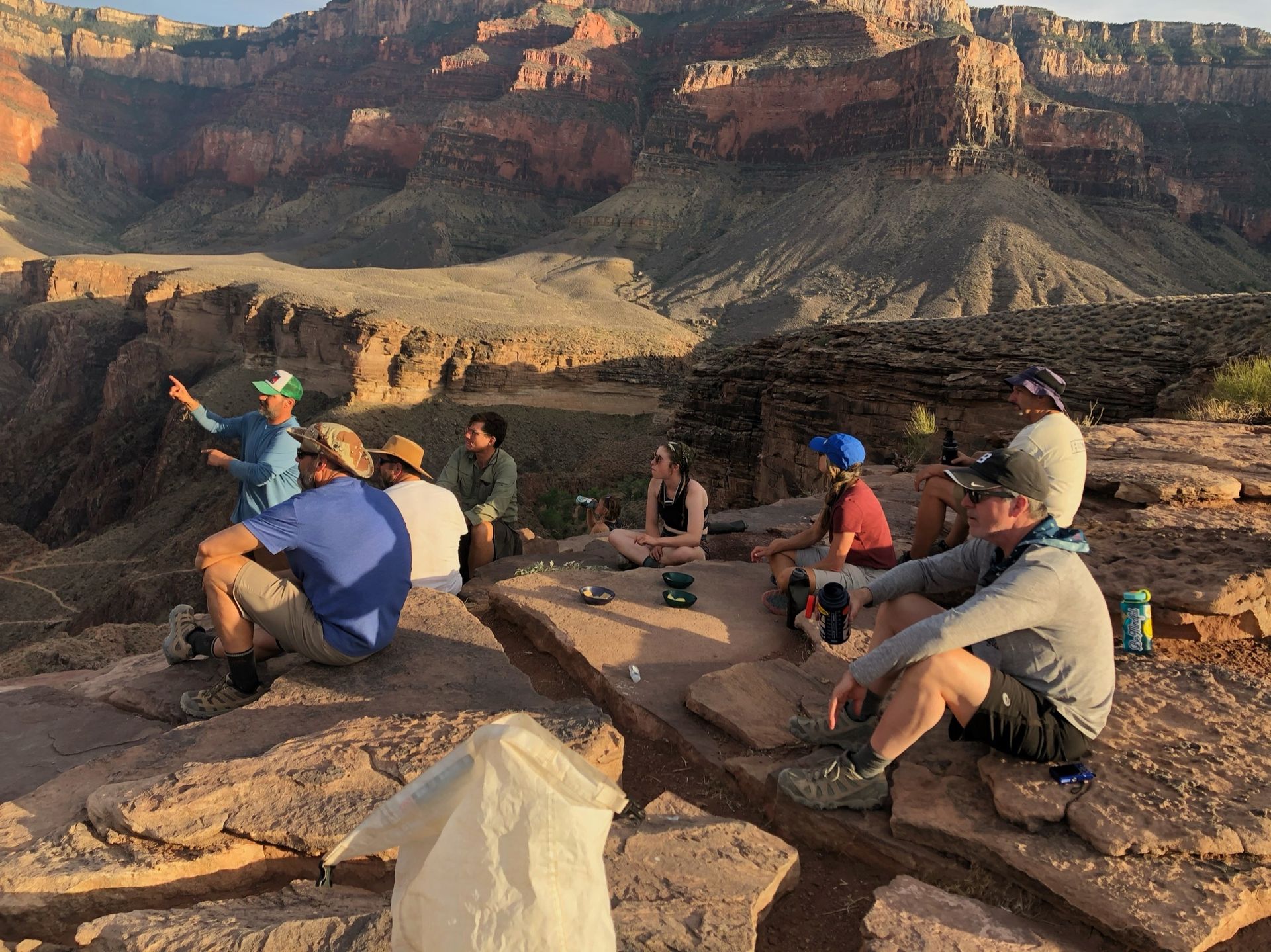 A group of people are sitting on top of a rocky cliff.