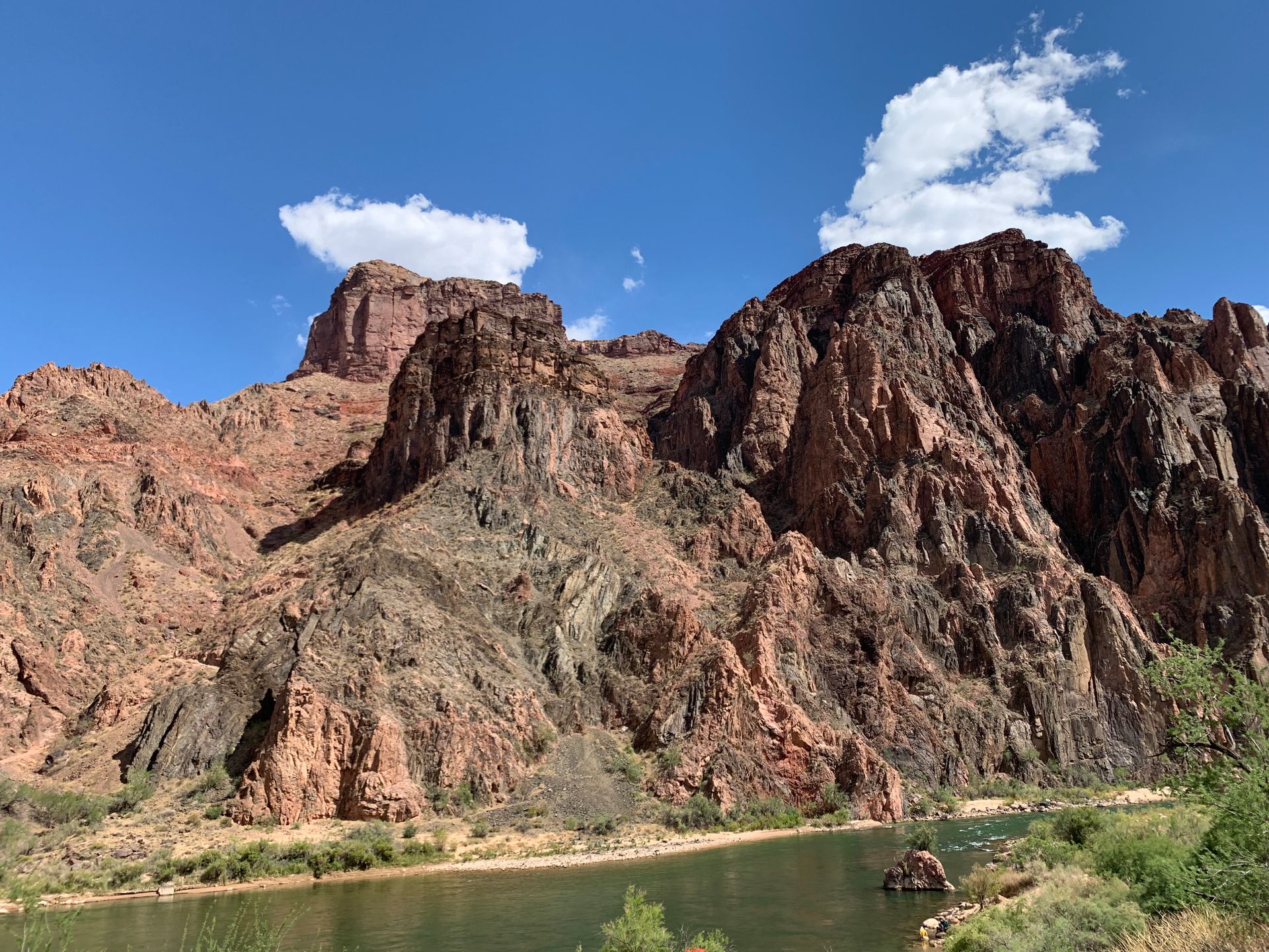 A river runs through a canyon with mountains in the background.