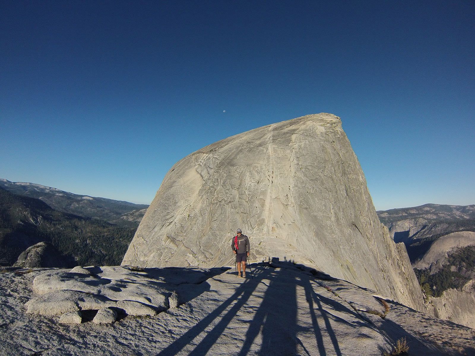 A person is standing on top of a large rock formation.