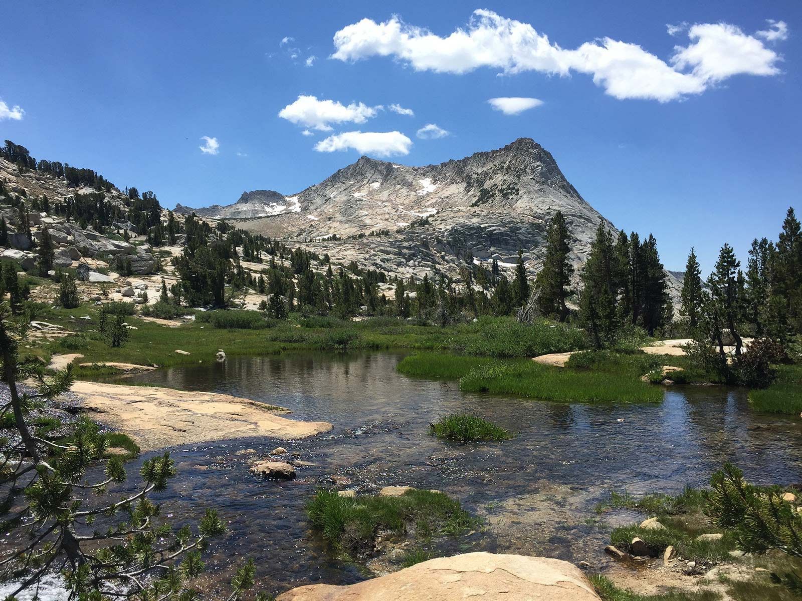 A lake in the mountains with a mountain in the background