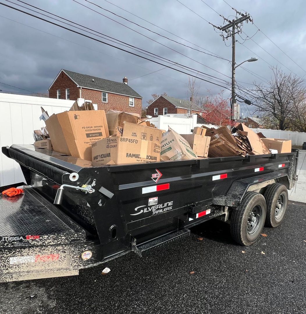 The back of a trailer filled with boxes and a dolly.