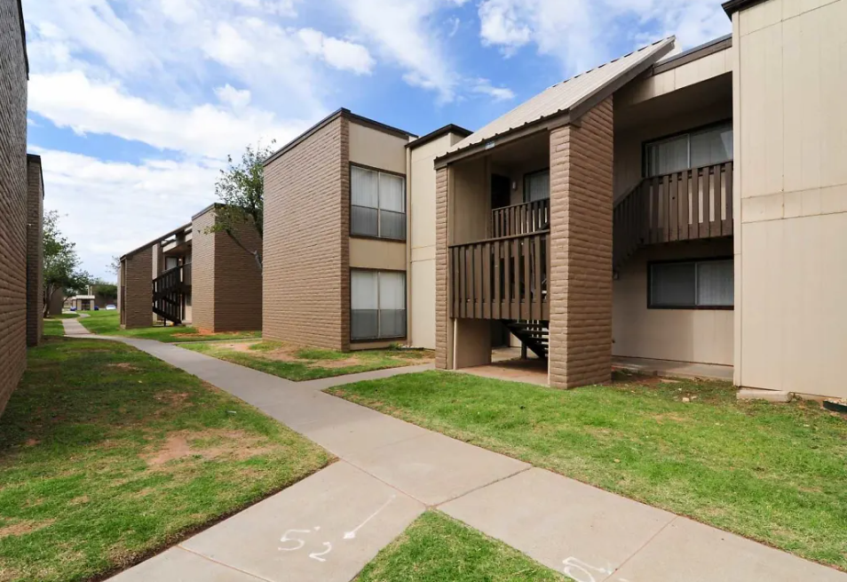 Exterior view of a brown apartment complex with walkways and stair entrances at Brookview, offering apartments in Odessa, TX.