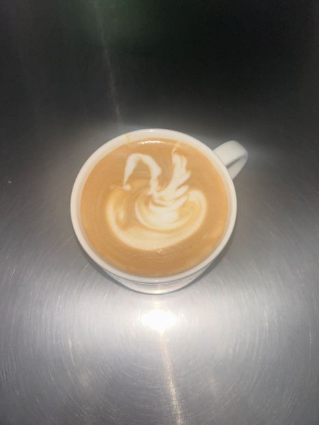 A cup of coffee with a swan design on it