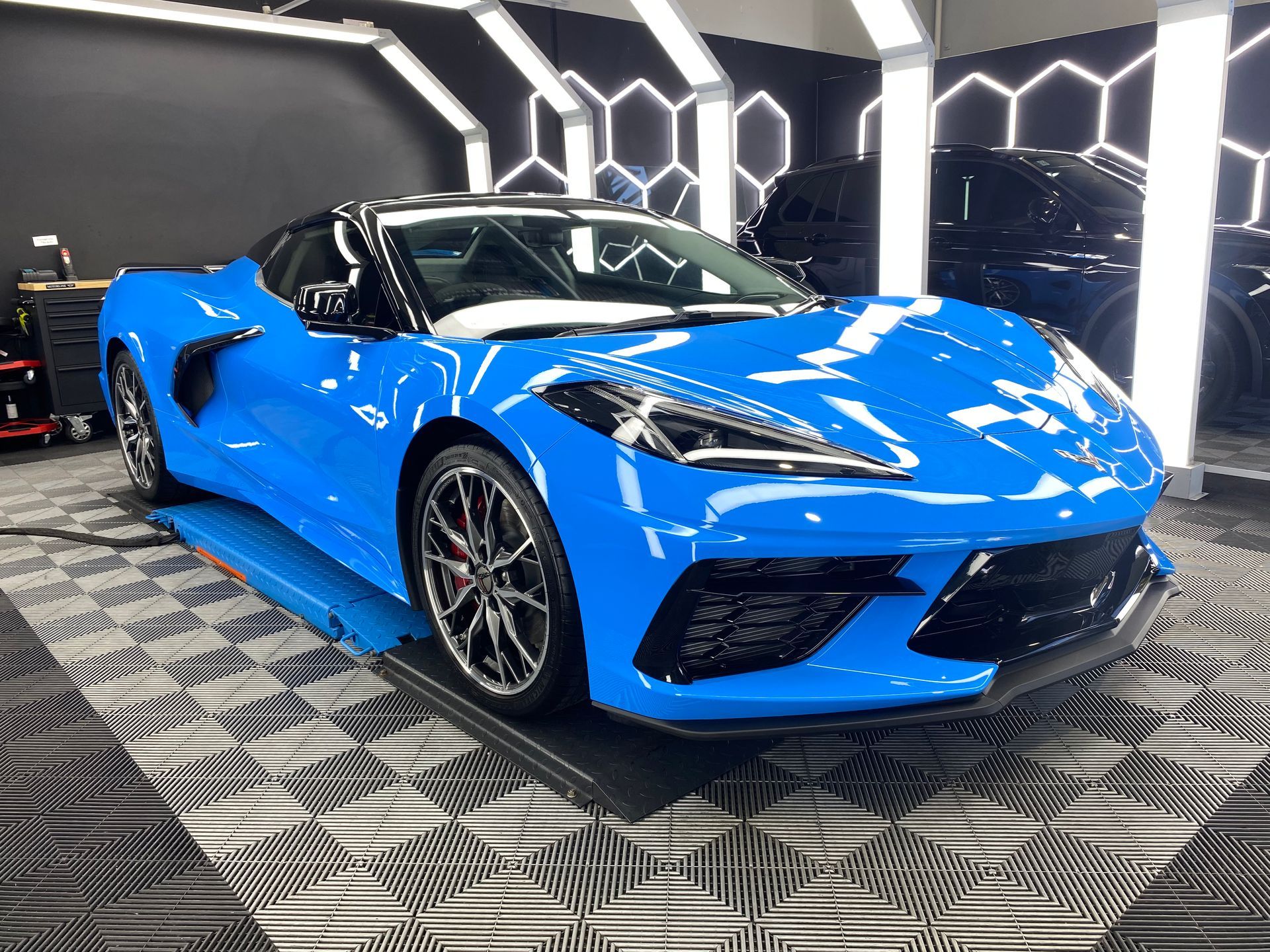 A blue sports car is parked in a garage.