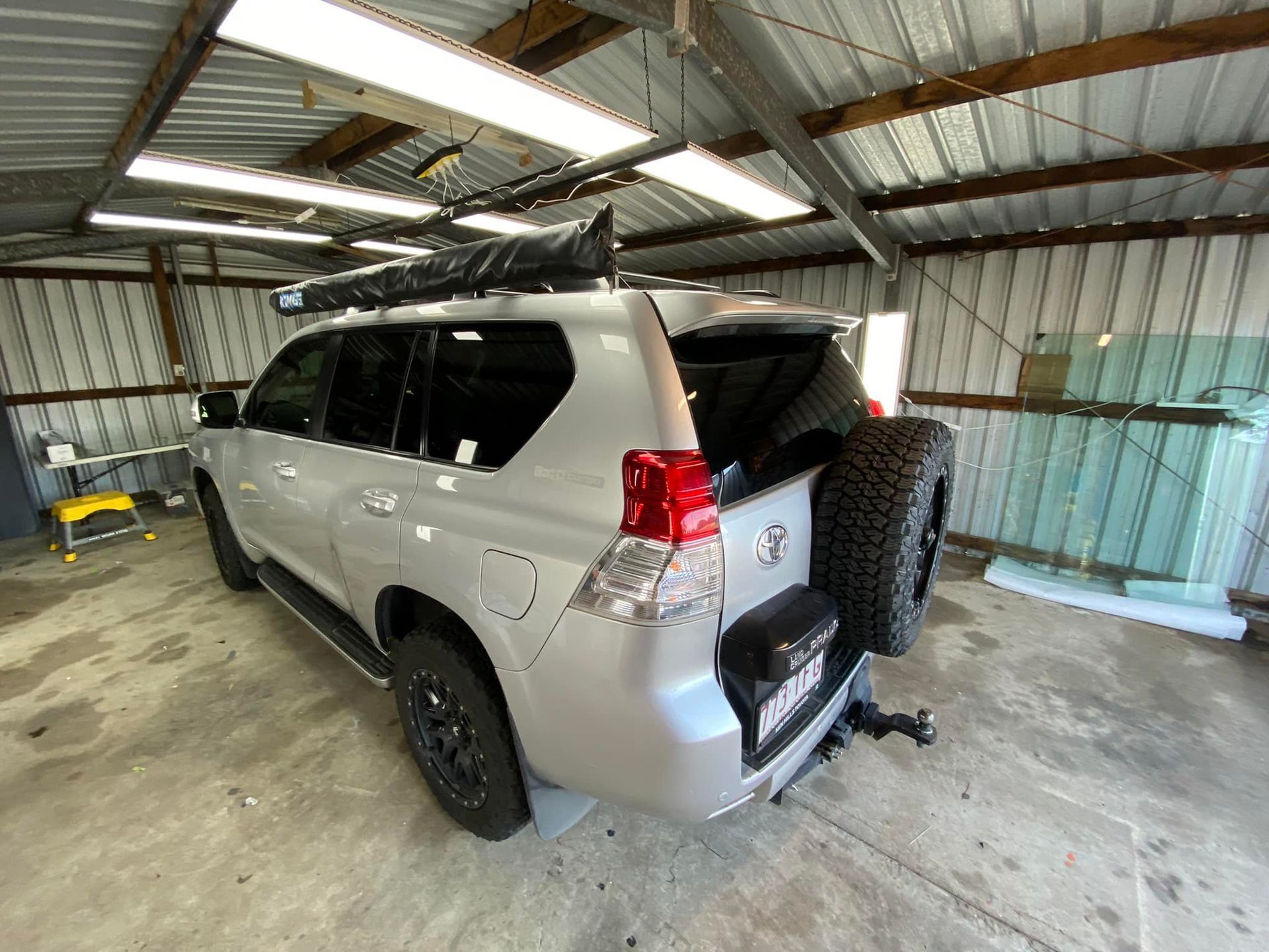 A silver toyota land cruiser is parked in a garage.