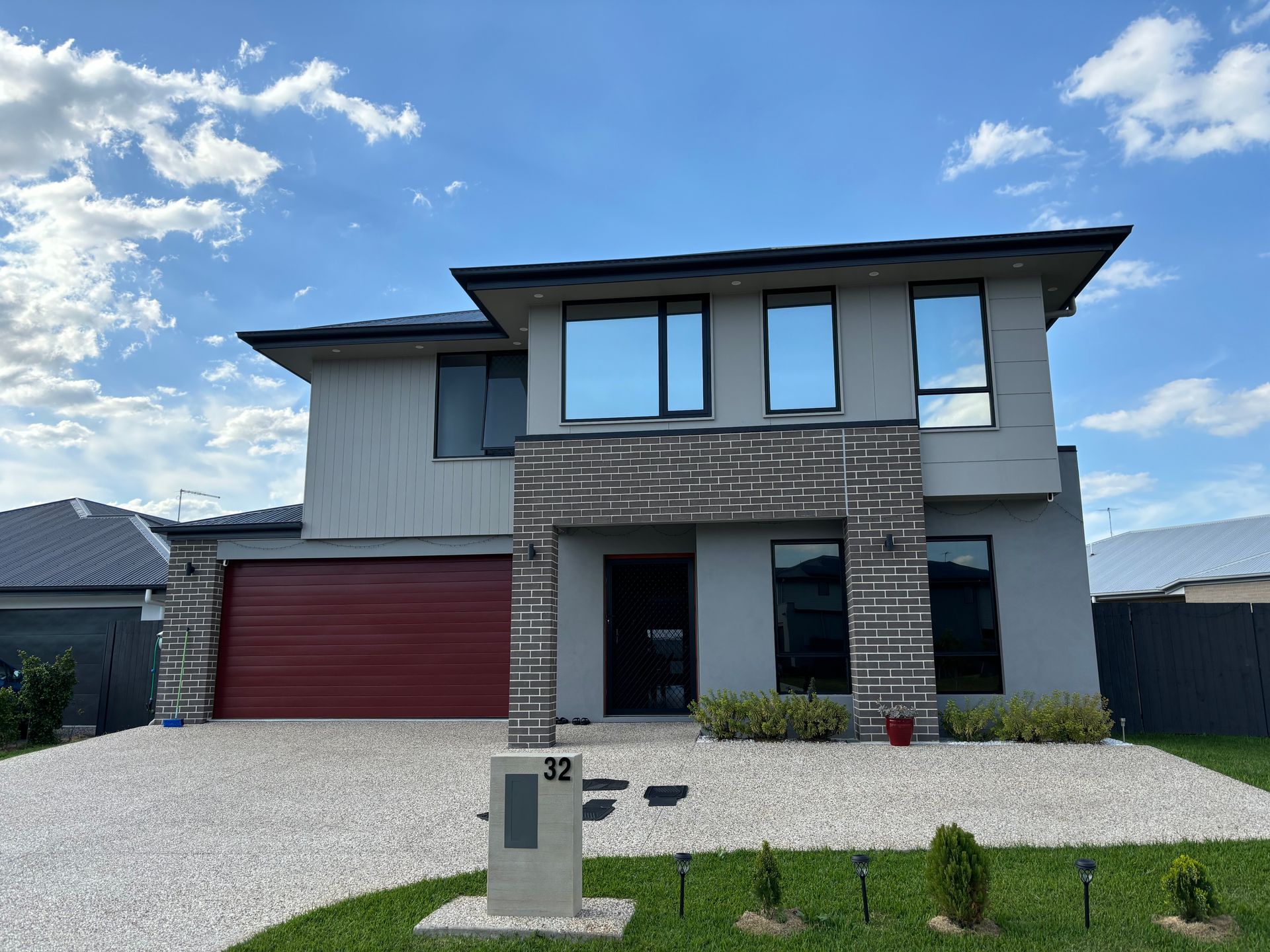 A large house with a red garage door and a lot of windows