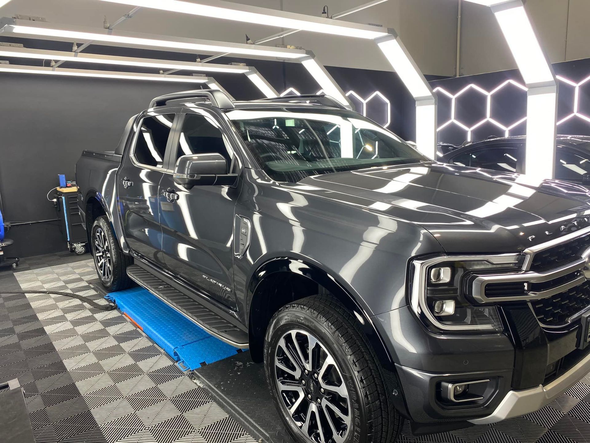 A gray truck is parked in a garage.