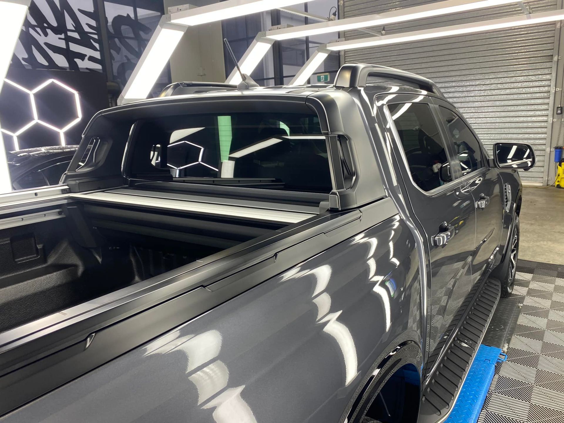 A black truck is parked in a garage.