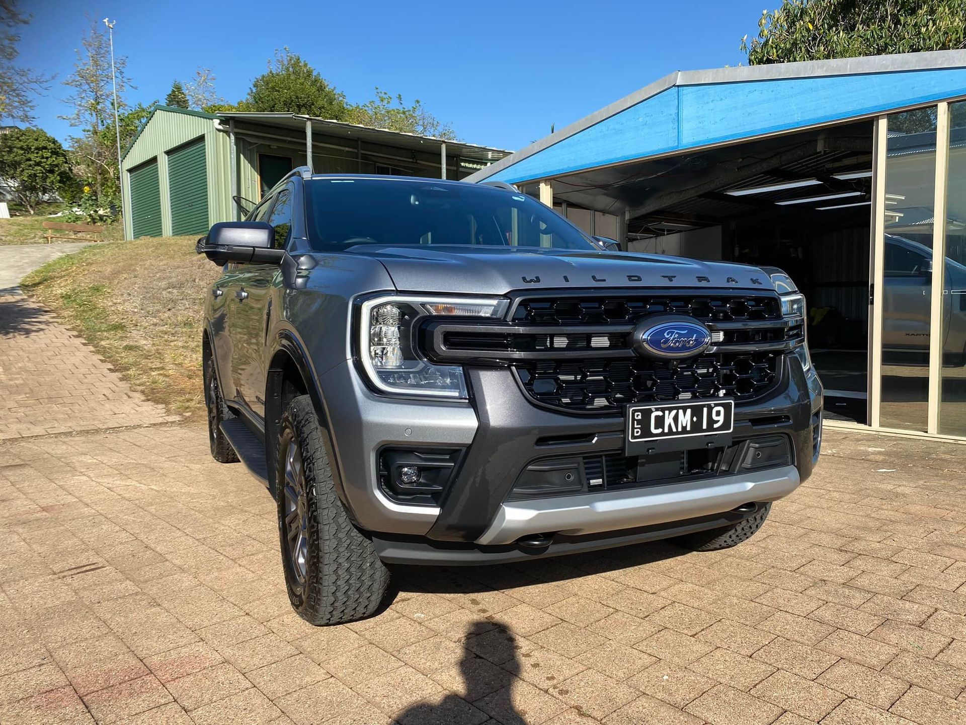 A ford ranger is parked in front of a garage.