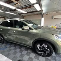 A green car is parked in a garage - window tinting by Tint Wright Brisbane