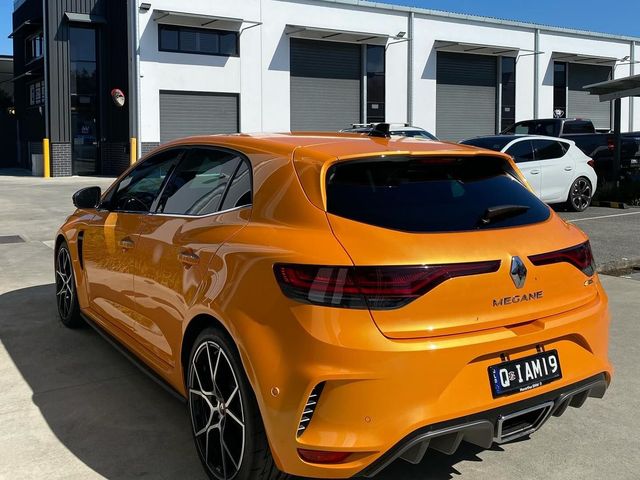 A renault megane rs hatchback is parked in front of a building - window tinting by Tint Wright Brisbane