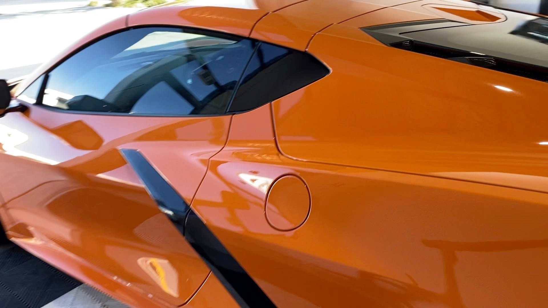 A close up of the side of an orange sports car
