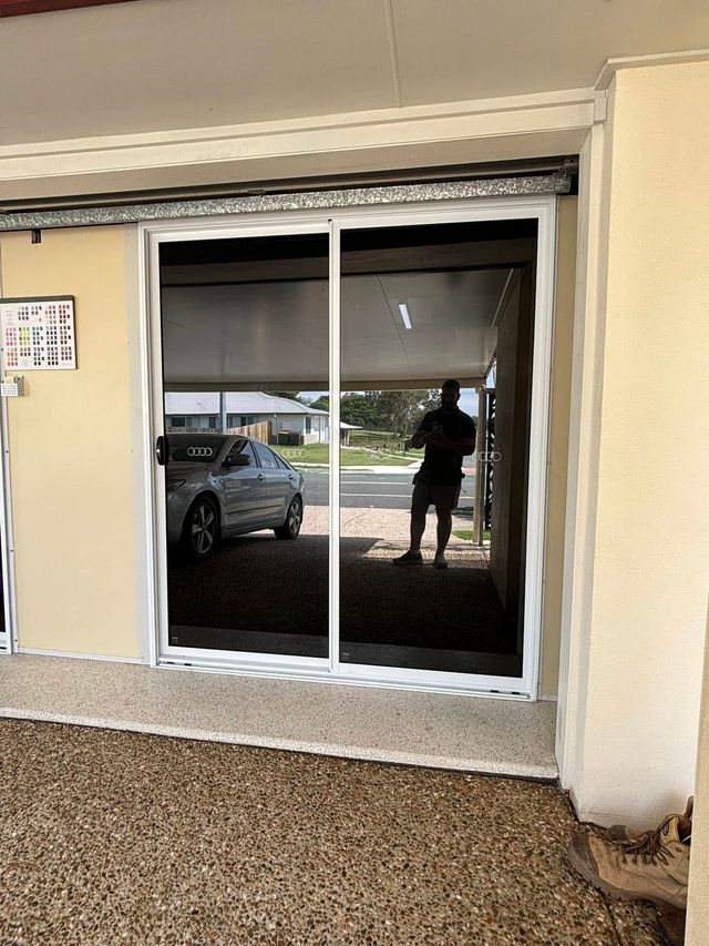 A man is standing in front of a sliding glass door - window tinting by Tint Wright Brisbane