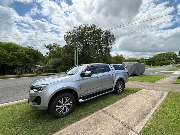 A silver truck with a canopy is parked on the side of the road - window tinting by Tint Wright Brisbane