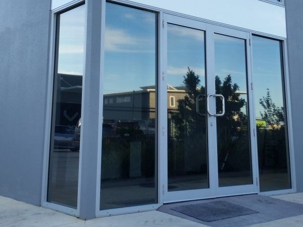 A building with a reflection of trees in the windows