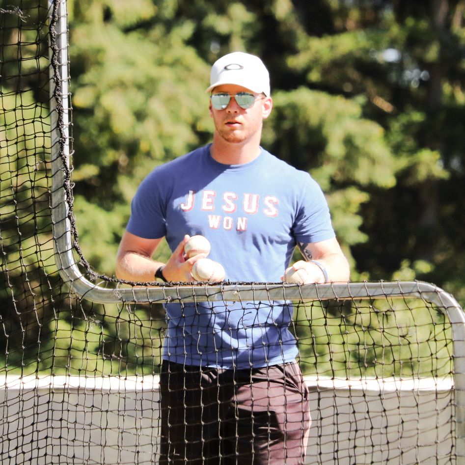 Ryan Dearing throwing pitches behind the net L-screen