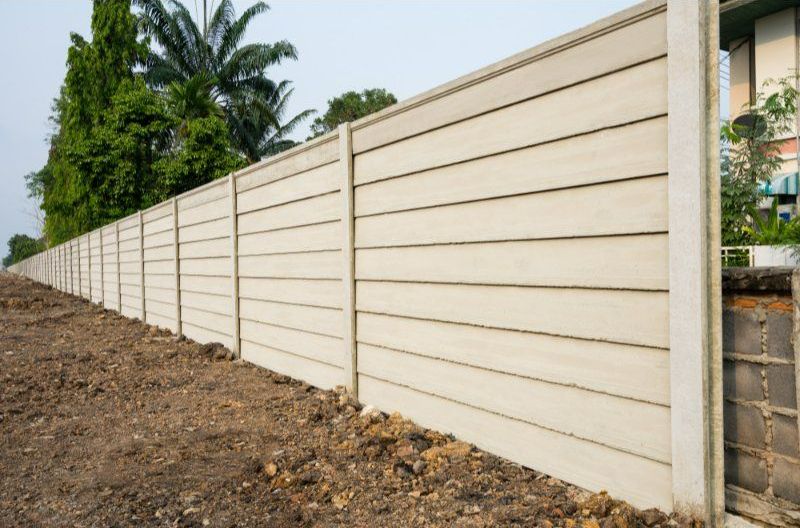 A Concrete Fence is Being Built in a Dirt Field — Turnscape Landscaping in Beechmont, QLD