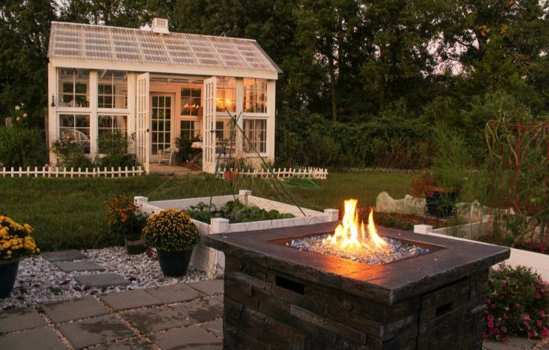 A Fire Pit is Lit Up in Front of a Greenhouse — Turnscape Landscaping in Burleigh Heads, QLD