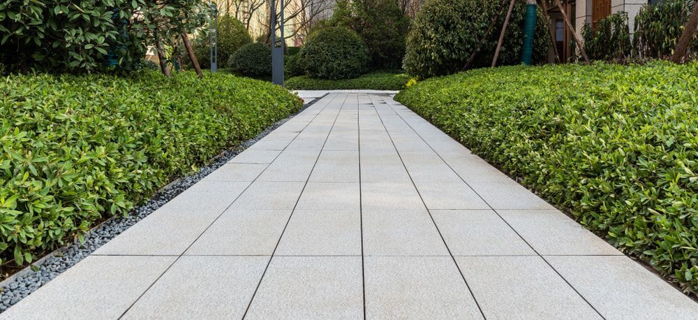A brick walkway surrounded by trees and bushes in a park. — Turnscape Landscaping In Broadbeach, QLD
