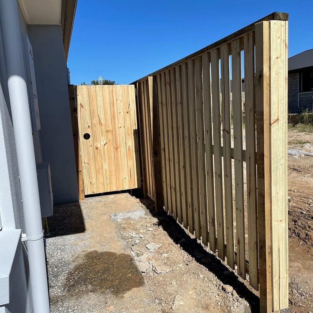 A wooden fence with a gate in the middle of it. — Turnscape Landscaping in Robina, QLD