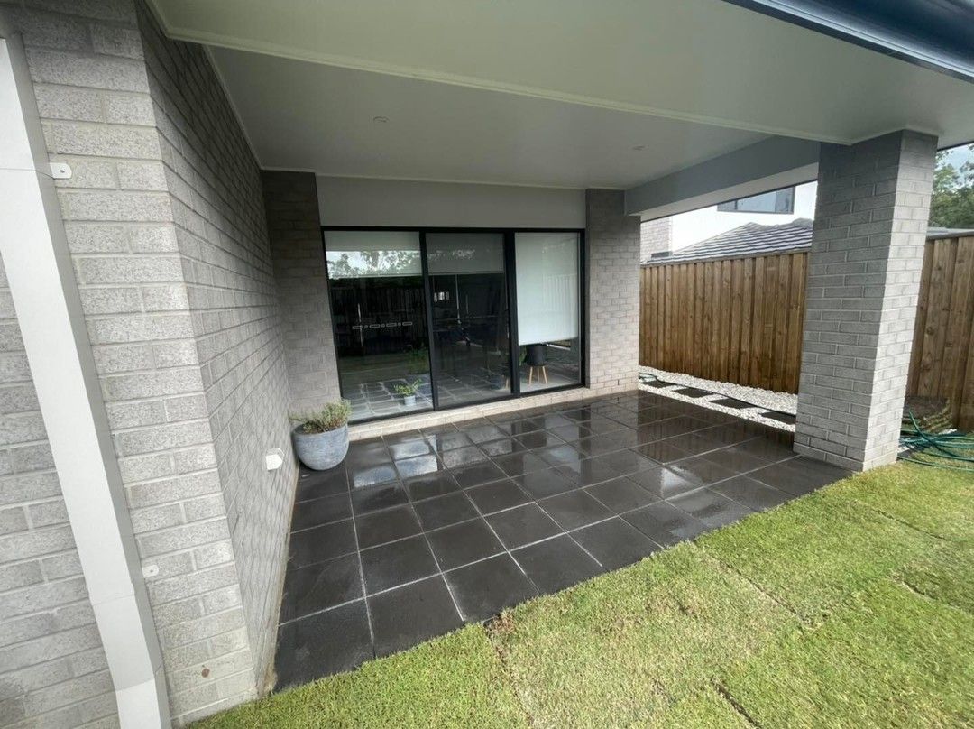 A patio with a sliding glass door and a fence in the background. — Turnscape Landscaping in Hope Island, QLD