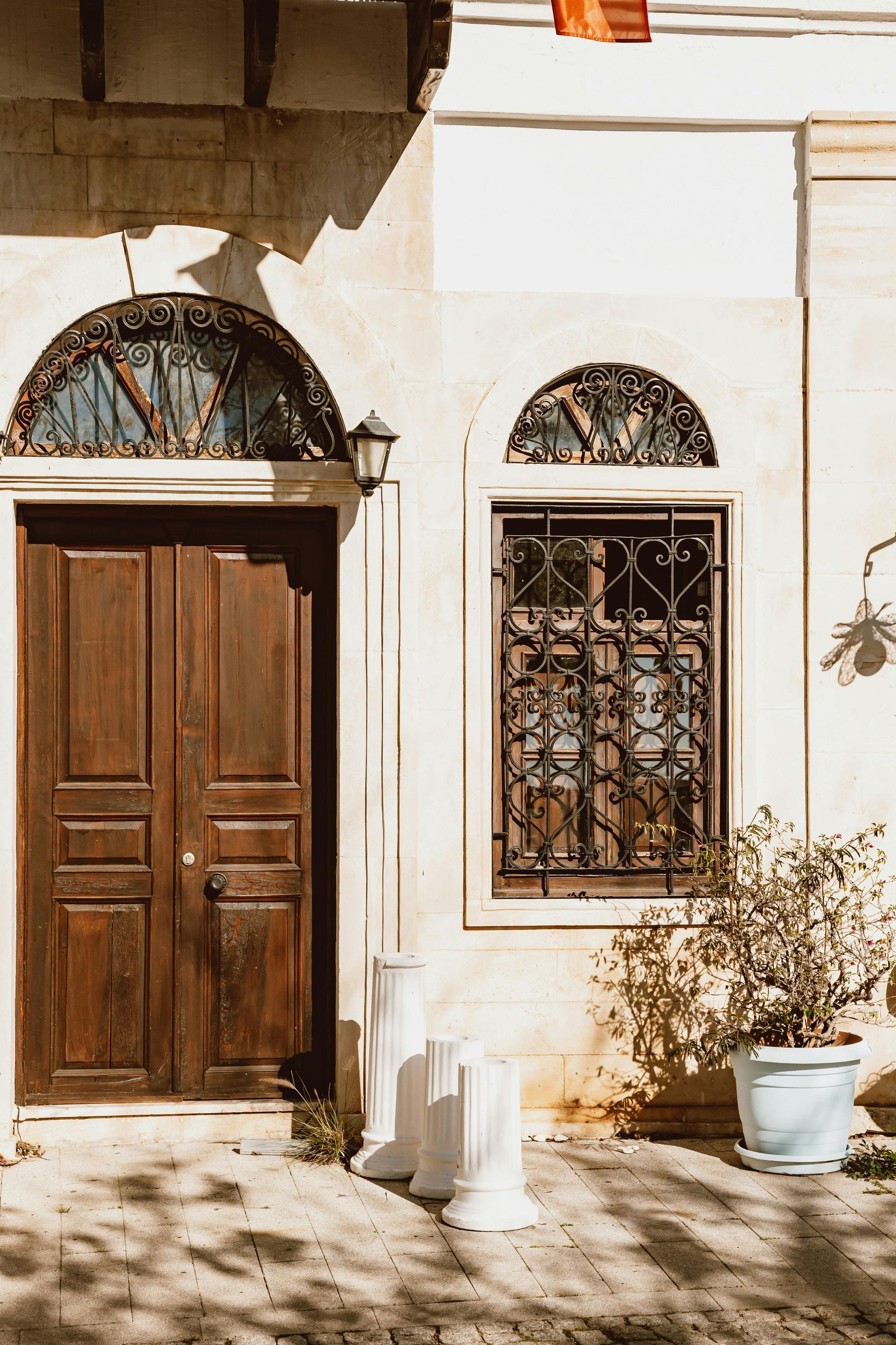 A white building with a wooden door and two windows.