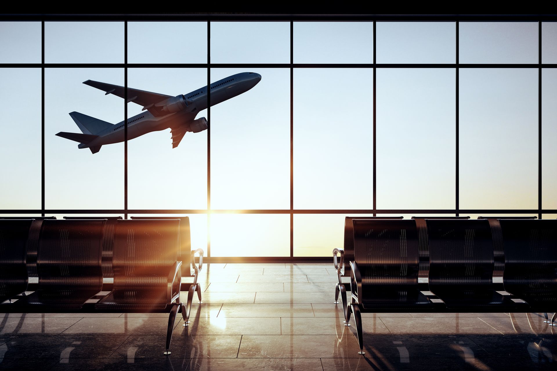 An airplane is flying over an airport waiting area.