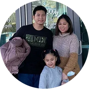 A family is posing for a picture in front of a building.