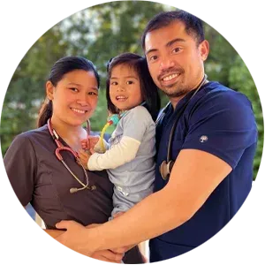 A family is posing for a picture in front of a building.