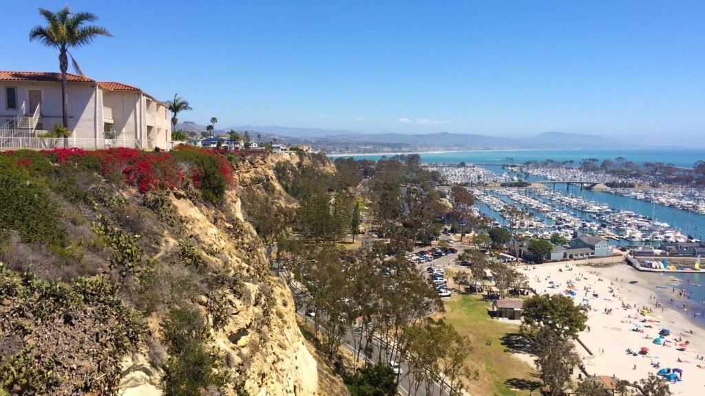 A view of a city from a cliff overlooking a beach.