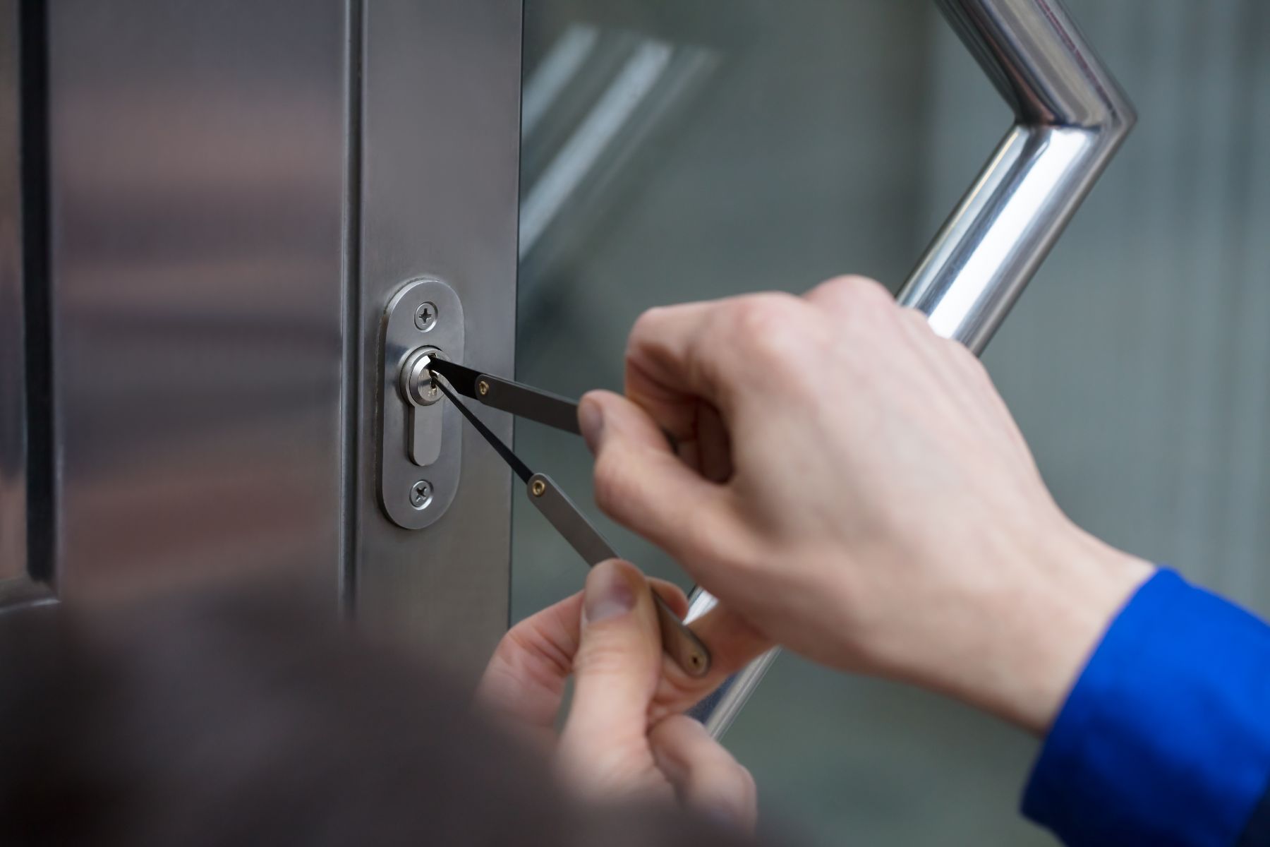 A person is using a key to open a door lock.