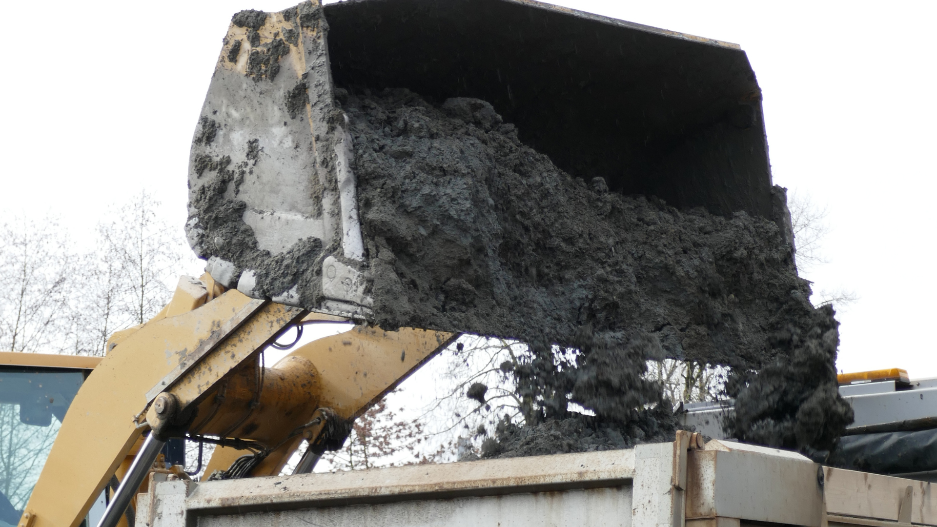 A pile of trash is sitting in front of a brick wall.
