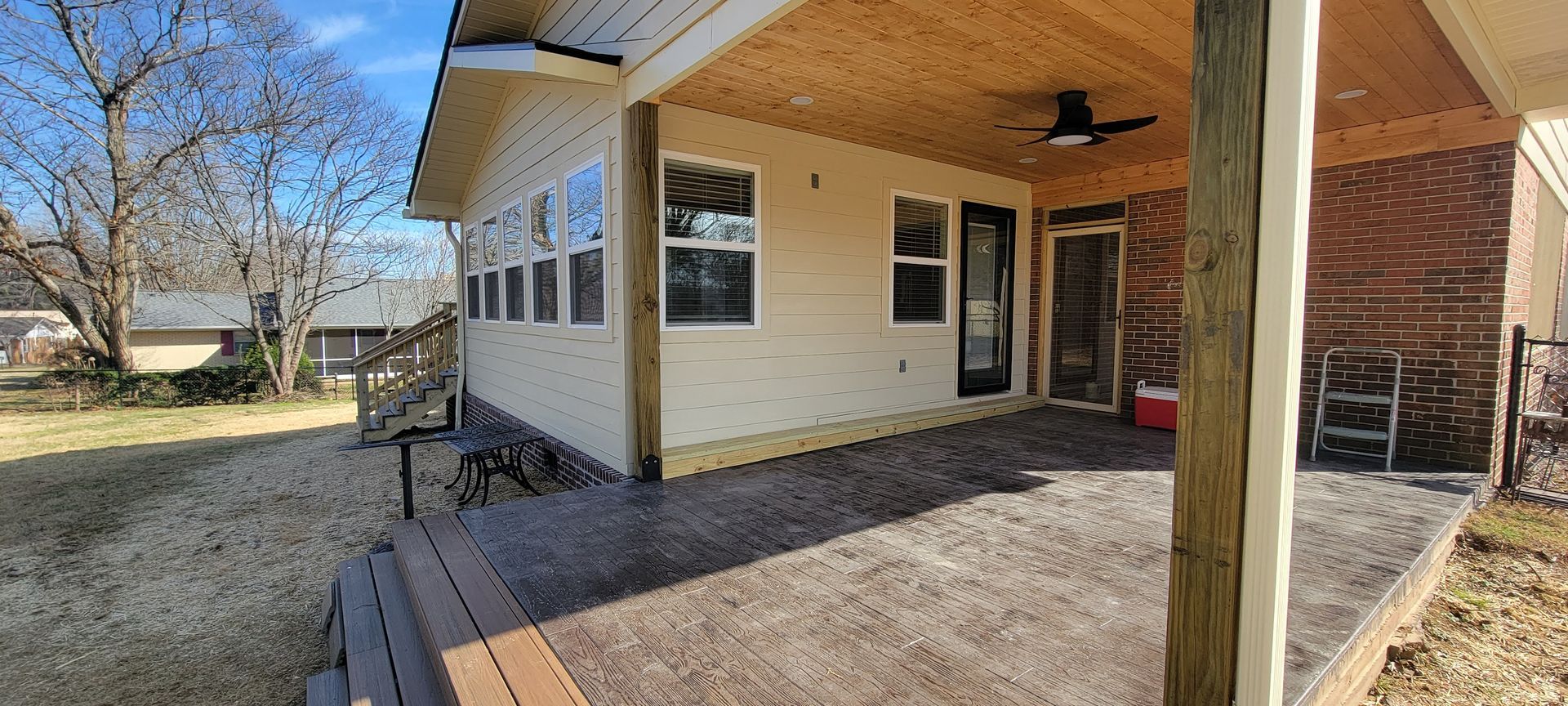 The back of a house with a porch and a ceiling fan.