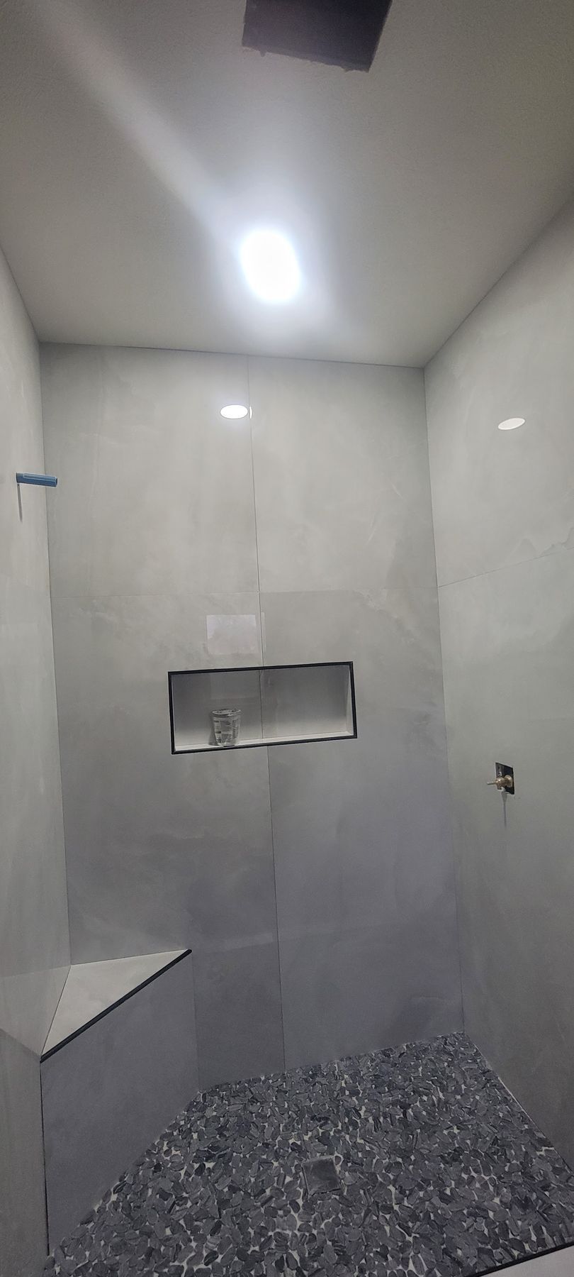 A bathroom with a walk in shower and a ceiling light.
