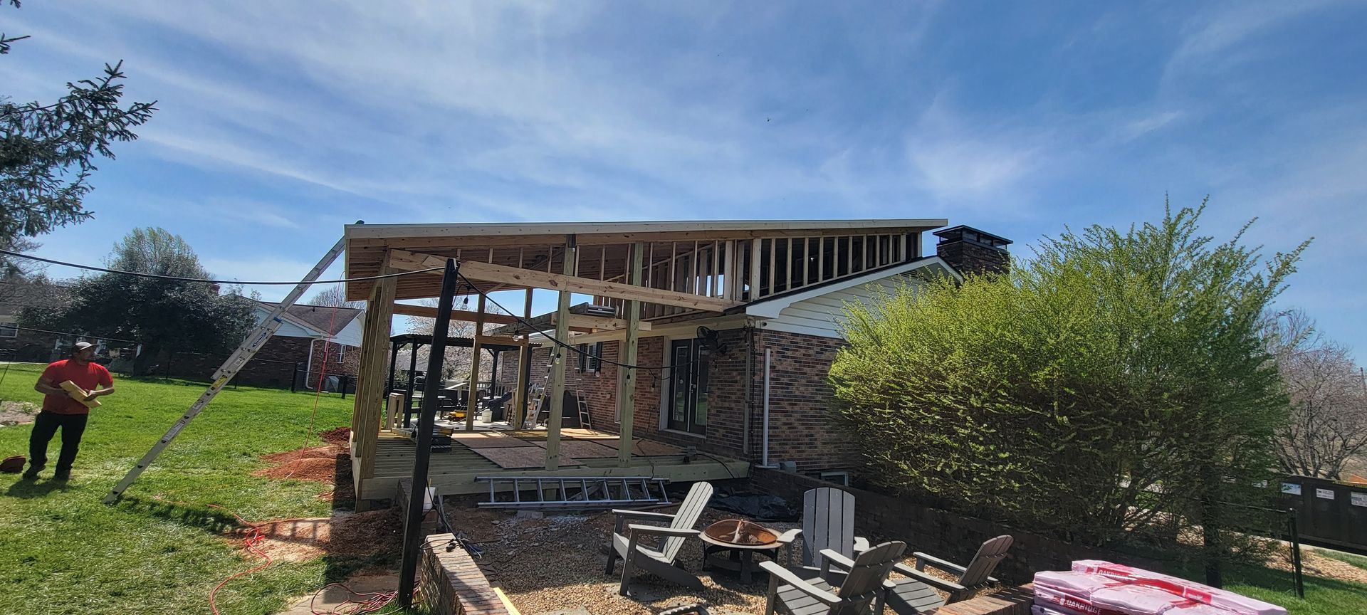 A man is standing in front of a house that is being built.