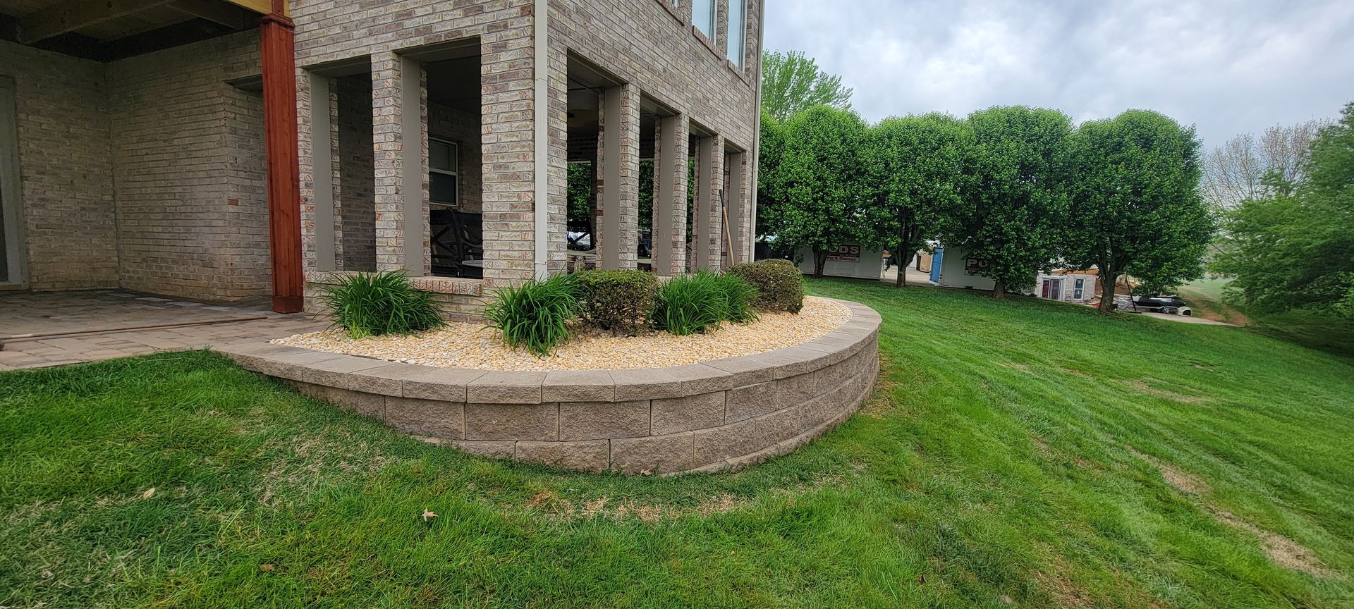 A large brick building with a lush green lawn in front of it.