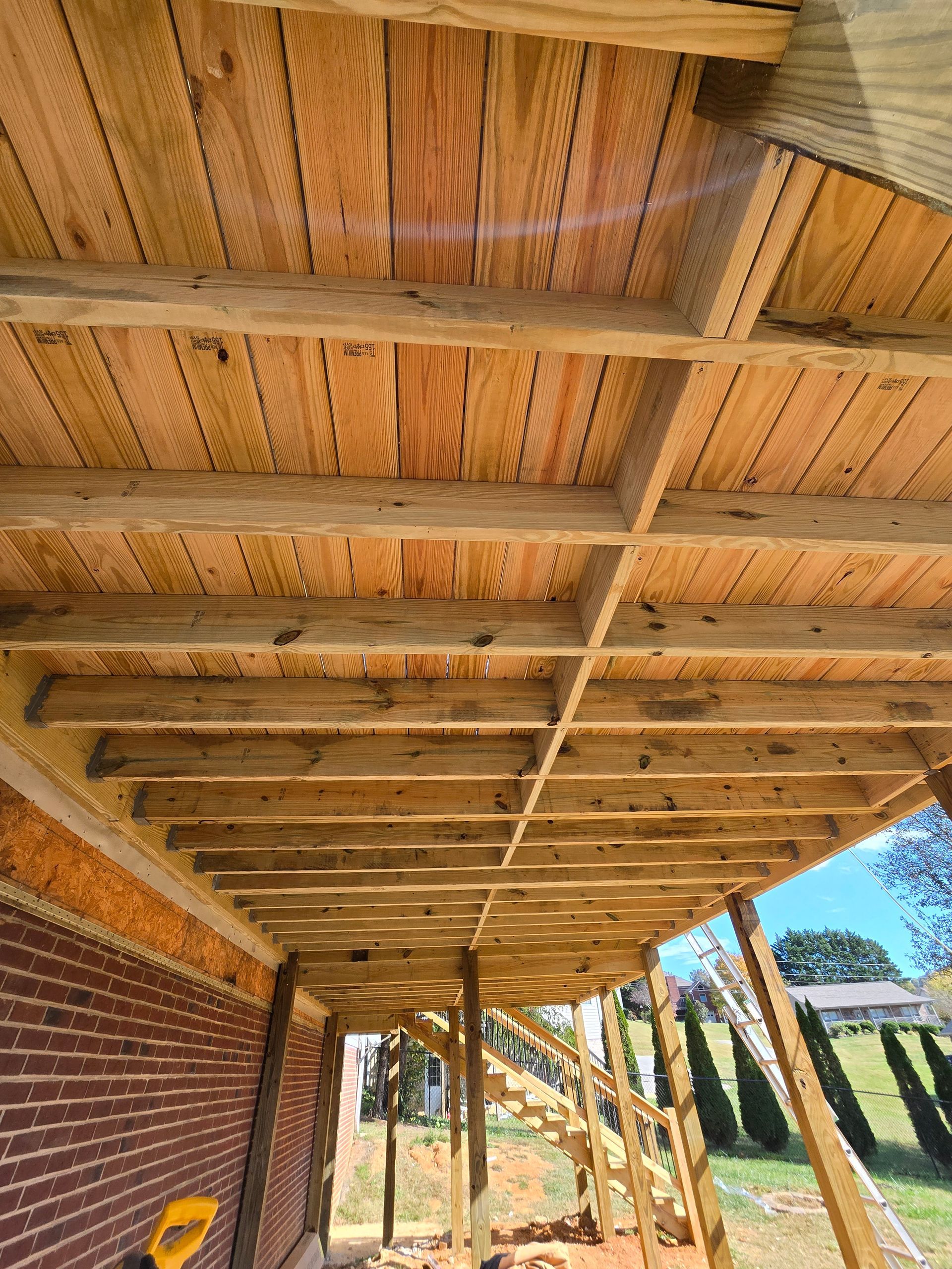 A wooden deck is being built on top of a brick building.