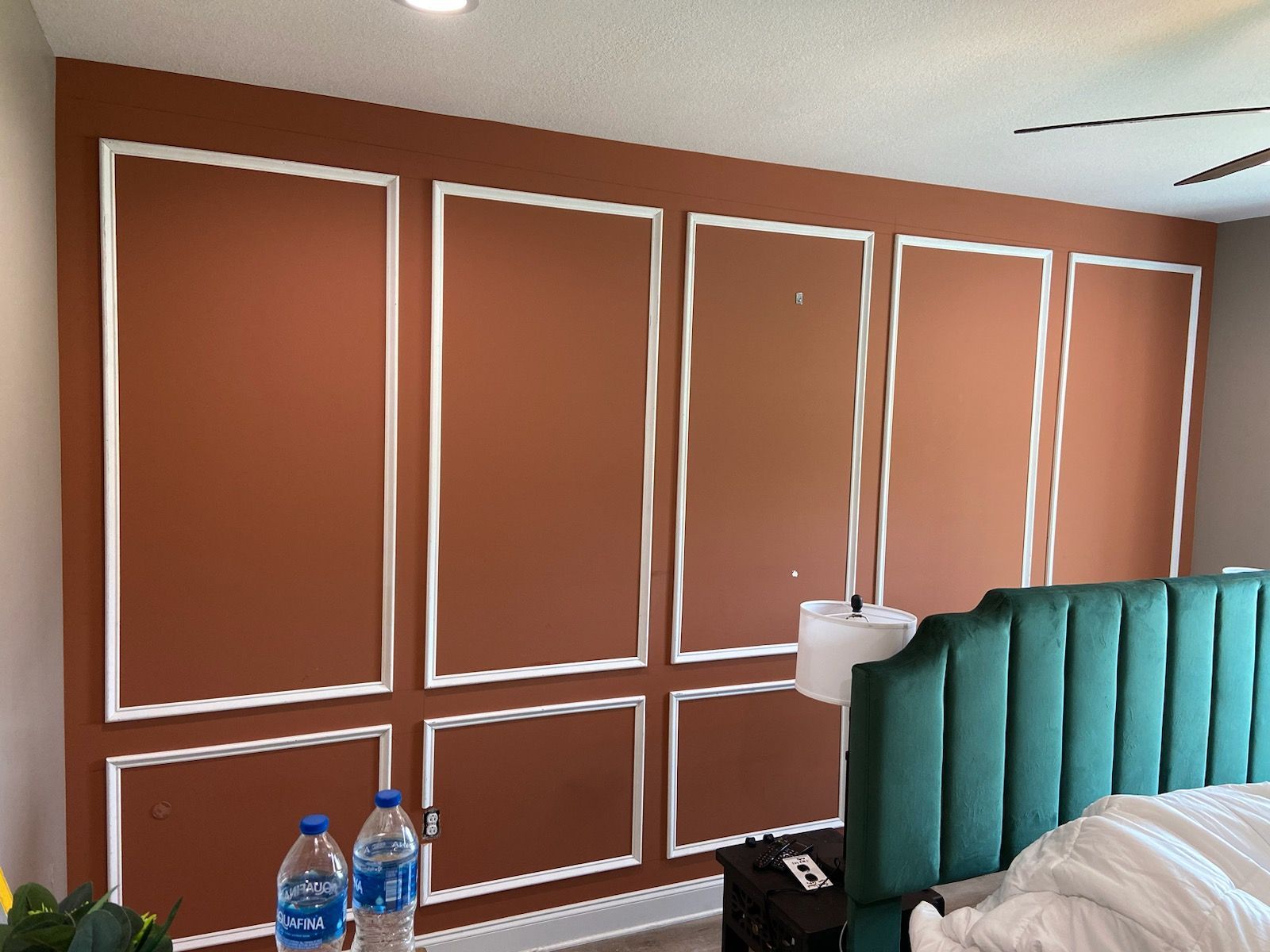 A bedroom with a bed and two bottles of water on a table.