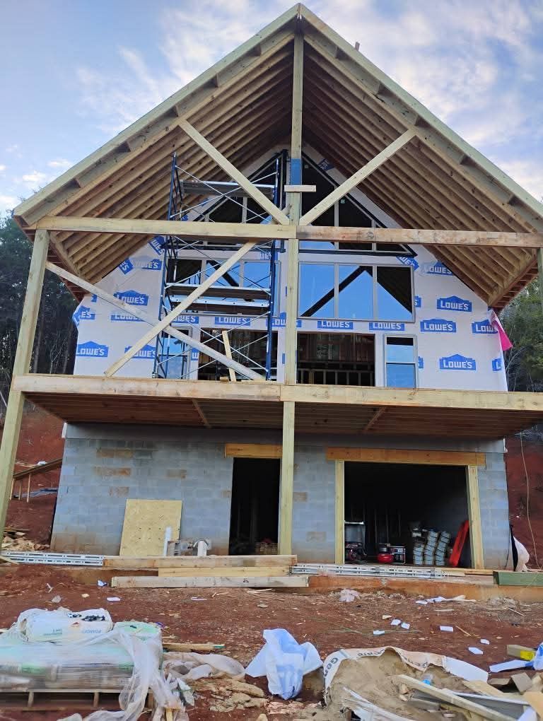 A house is being built with a wooden frame and a roof.